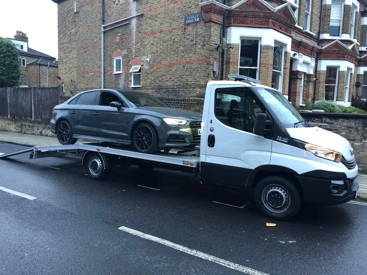 Recovery truck transporting a vehicle in London