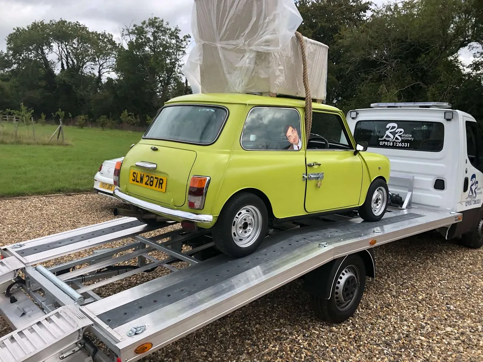 Classic Mini car being loaded onto a Reliable Recovery truck in London