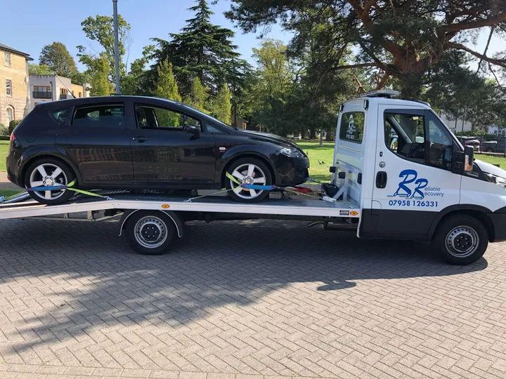 Recovery vehicle transporting a car in London